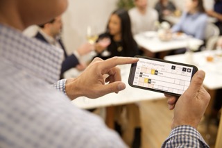 Restaurantleiter nutzt Carbonara auf dem Smartphone während des Service